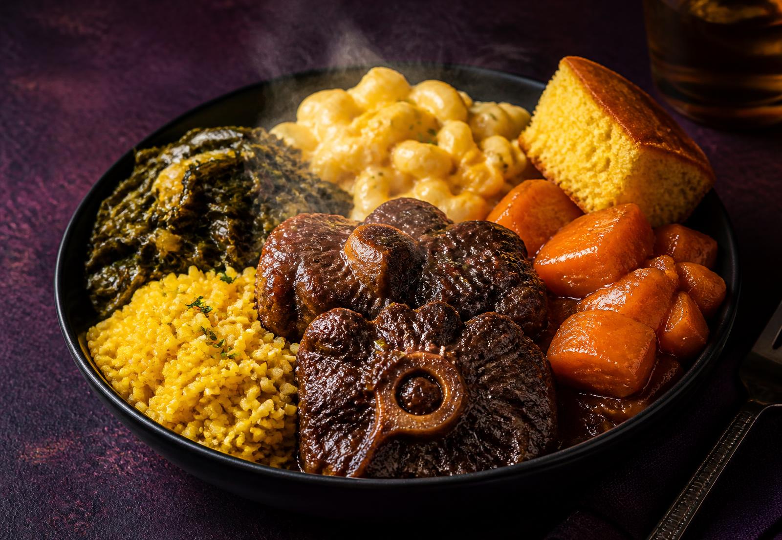 Divine Delightz oxtail bowl with yellow rice, collard greens, mac n cheese, candied yams and cornbread